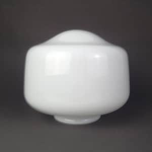 May include: A white, opaque glass lamp shade with a smooth, rounded dome top and a cylindrical body that tapers slightly toward a circular opening at the base. The surface of the glass is uniform and reflects light evenly across its curved exterior.