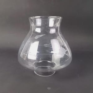 Puede incluir: Una taza de cerámica blanca con asa negra y el texto "But First, Coffee" en negrita negra. La taza se encuentra sobre un fondo borroso, sugiriendo un ambiente acogedor.