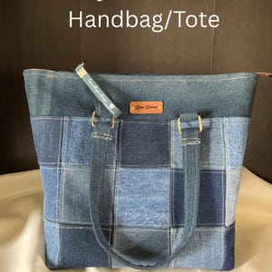 Puede incluir: Bolso/tote bag de mezclilla reciclada con diseño de patchwork en varios tonos de azul. El bolso tiene asas resistentes, cierre de cremallera y una pequeña etiqueta de cuero. El texto "Recycled Denim Handbag/Tote" y "Dena Dianna Inspirations" son visibles.