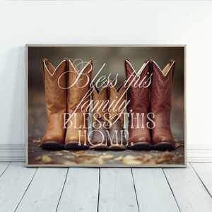 Peut inclure: Impression encadrée avec cinq bottes de cowboy de différentes nuances de marron. Les bottes sont disposées comme une famille, avec l'inscription "Bless this family, Bless this home" en lettres décoratives sur l'image.
