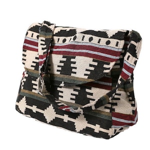 May include: A black, white, red, and green patterned tote bag with a long strap. The bag has a geometric design.