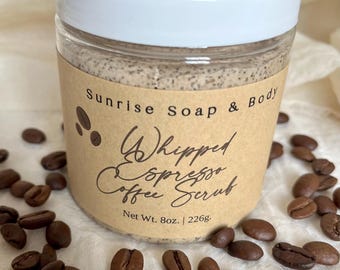 May include: A clear jar with a white lid, labeled "Sunrise Soap & Body Whipped Espresso Coffee Scrub." The jar contains a brown scrub and is surrounded by coffee beans. Net weight is 8 oz.