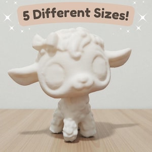 May include: A white lamb figurine with large eyes and a bow on its head. The text "5 Different Sizes!" is displayed above the figurine. The lamb is standing on a wooden surface.