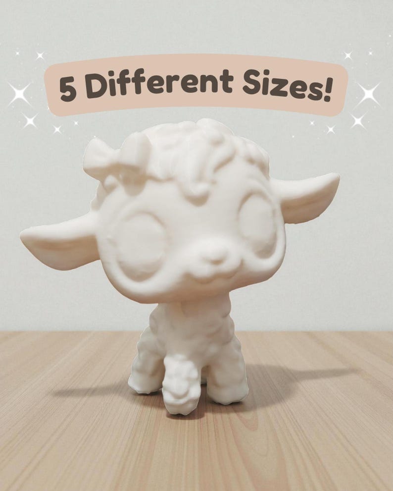 May include: A white lamb figurine with large eyes and a bow on its head. The text "5 Different Sizes!" is displayed above the figurine. The lamb is standing on a wooden surface.