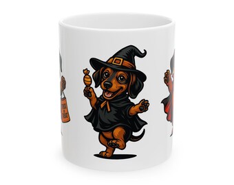 Op de afbeelding: Witte keramische mok met een Halloween-thema. Het toont een cartoon teckel in een heksenkostuum, compleet met een zwarte hoed en cape, met een snoepje. Een "Trick or Treat"-tas is ook zichtbaar.