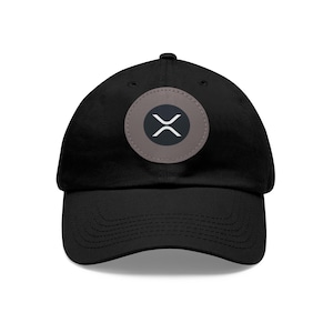 Pode incluir: Boné de beisebol preto com aba curva. O boné apresenta um patch circular com o logotipo da criptomoeda XRP em branco sobre um fundo cinza. O chapéu é feito de um material macio e tem um estilo clássico e casual.