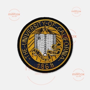May include: Circular patch with a navy blue border and gold embroidery. The center features an open book, the text "LET THERE BE LIGHT", and "THE UNIVERSITY OF CALIFORNIA" around the edge. The year "1868" is at the bottom.