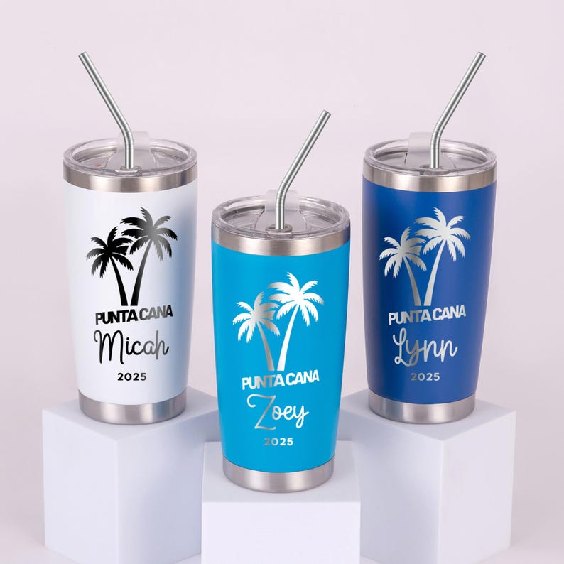 May include: Three stainless steel tumblers with lids and straws. Each tumbler is a different color: white, turquoise, and blue. They feature a palm tree design and the text "Punta Cana" with a name and the year 2025.