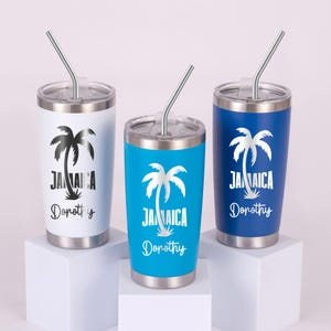 May include: Three stainless steel tumblers with lids and straws. One is white, one is blue, and one is navy. Each tumbler has a palm tree graphic and the word "Jamaica" with a name below.