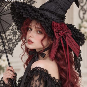 May include: A black witch hat featuring a textured fabric, wide ruffled lace brim, and deep red fabric roses with a matching ribbon bow. The hat includes a black ribbon chin tie and the text Velphira is visible in the upper left corner.