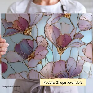 May include: A rectangular glass panel featuring a stained glass style floral pattern with translucent purple and pink petals outlined in gold metallic lines against a pale blue background. The text Paddle Shape Available is printed below.