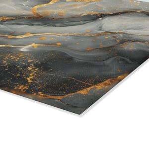 May include: A rectangular wall art panel featuring an abstract fluid ink design. The surface displays swirling layers of charcoal gray, slate, and black tones, accented by prominent, flowing veins and scattered droplets of metallic gold paint.
