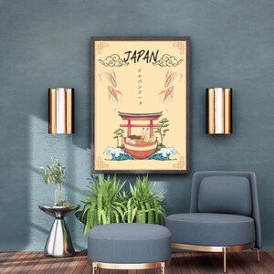 Peut inclure: Une affiche encadrée sur le thème du Japon, avec un torii rouge, des ramen et des vagues. Le mot "JAPAN" est en haut, avec des caractères japonais en dessous. L'affiche est accrochée à un mur bleu-vert, au-dessus d'un pouf et d'une chaise gris avec des pieds dorés.