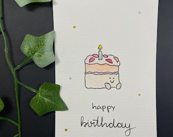 May include: Hand-drawn birthday card featuring a two-layer cake with a lit candle. The cake has pink frosting and a smiling face. The words "happy birthday" are written below the cake in cursive.