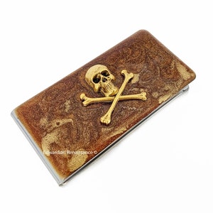 Clip para billetes de calavera y tibias cruzadas de oro antiguo con incrustaciones en esmalte de bronce metálico inspirado en estilo victoriano gótico con opciones personalizadas y de color