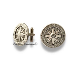 May include: A pair of silver cufflinks with a compass design. The compass features a star with eight points and the letters N, S, E, and W around the edge.