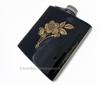 Peut inclure: Une fiole noire avec un motif de rose en relief doré. La fiole est gravée du texte "Edwardian Renaissance".