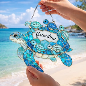 May include: A blue and turquoise stained glass turtle with the word "Grandma" and the names Ashley, Lucas, Charles, Peter, and Sophia. The turtle is held by a chain and has a beach background.