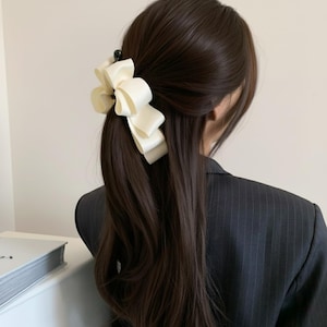 May include: A white ceramic mug with a black handle and the text "But First, Coffee" in a bold, black font. The mug is set against a blurred background, suggesting a cosy setting.