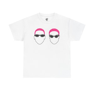 Peut inclure: T-shirt blanc avec un motif de deux visages stylisés portant des lunettes de soleil et des cheveux roses. Le design est minimaliste, avec des contours noirs et une palette de couleurs simple. Le t-shirt a un col rond et des manches courtes.