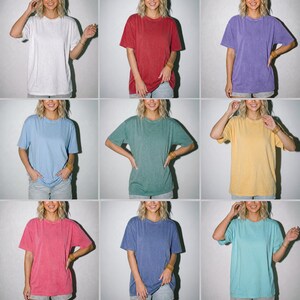 Pode incluir: Uma cole&ccedil;&atilde;o de nove camisetas de manga curta com gola redonda em v&aacute;rias cores s&oacute;lidas, incluindo branco, vermelho, roxo, azul claro, verde, amarelo, rosa, azul escuro e turquesa, cada uma com um corte relaxado e um design cl&aacute;ssico.