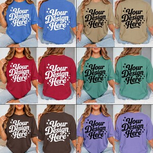 Pode incluir: Uma cole&ccedil;&atilde;o de camisetas de manga curta em azul, bege, vermelho, verde-azulado, marrom e roxo. Cada camiseta apresenta o texto Your Design Here em uma fonte cursiva em negrito, acentuada por &iacute;cones de estrelas de quatro pontas, na frente e atr&aacute;s.