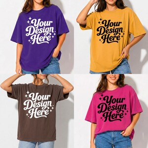 May include: Four oversized t-shirts in purple, gold, brown, and pink. Each shirt features the text "Your Design Here" in a stylized font. The shirts are worn with denim shorts, showcasing a casual, relaxed style.
