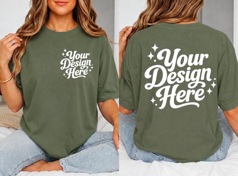 May include: Olive green t-shirt with the text "Your Design Here" in white script on the front and back. The design is surrounded by starburst accents. The shirt has short sleeves and a relaxed fit.
