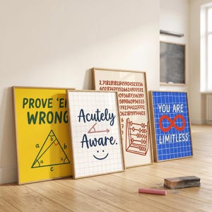 May include: Four framed wall art prints with mathematical themes. One yellow print says PROVE 'EM WRONG with a triangle diagram. A white grid print says Acutely Aware with an angle symbol and smiley face. A beige print shows digits and an abacus. A blue grid print says YOU ARE LIMITLESS with an infinity symbol.