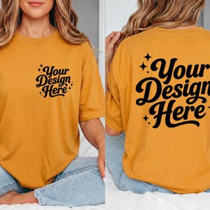 May include: Mustard yellow t-shirt with the text "Your Design Here" in black script on the front and back. The design is surrounded by small starbursts. The shirt is a casual, oversized fit.