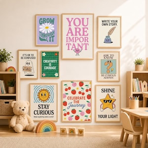 Peut inclure: Un ensemble de neuf affiches murales encadrées avec des textes de motivation et des illustrations colorées, dont une marguerite, un fantôme, un soleil, des cerises et une étoile, disposées en galerie avec des cadres en bois clair.