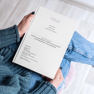 May include: A white book titled "Analyse der Auswirkungen von ChatGPT auf die Lehrmethoden und Prüfungsverfahren in Lehrveranstaltungen" is held by a person wearing a blue sweater and jeans. The book features the logo "TEMPLAJA" at the top.