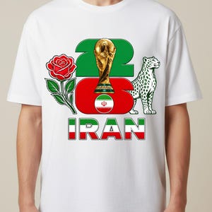 Puede incluir: Camiseta blanca con un dise&ntilde;o que incorpora los colores de la bandera iran&iacute;. El dise&ntilde;o incluye un trofeo dorado, una rosa roja, un guepardo y el n&uacute;mero "22". Tambi&eacute;n aparece la palabra "IRAN".