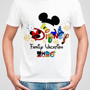 May include: White t-shirt featuring a colorful Disney design. The design includes Mickey Mouse ears, the word "DISNEY" in various colors, and the text "Family Vacation 2026". The shirt has a crew neck and short sleeves.