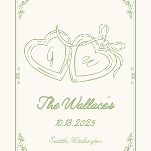May include: An invitation card with a cream background and a green border. Two heart-shaped lockets are connected with a ribbon. The text reads "The Wallace's", the date "10.13.2025", and the location "Seattle, Washington".
