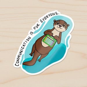 May include: A sticker featuring a cartoon otter holding a green and white tablet. The otter is brown with a white belly and is floating on a blue wave. The text "COMMUNICATION IS FOR EVERYONE" is written around the otter in white.