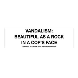 Puede incluir: Adhesivo rectangular blanco con texto negro. El texto dice: "VANDALISMO: HERMOSO COMO UNA ROCA EN LA CARA DE UN POLICÍA." Debajo, "Cortesía de Feederz: Office of Anti-Public Relations."