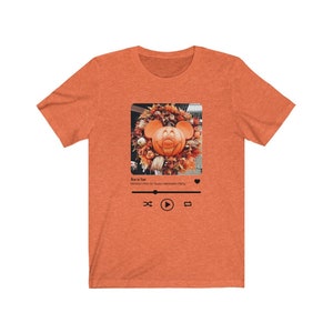 May include: Orange t-shirt with a graphic of a Mickey Mouse pumpkin on a social media post. The text on the post reads "Boo to You! Mickey's Not So Scary Halloween Party".