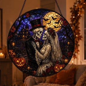 May include: A circular stained glass suncatcher featuring a skeleton couple in wedding attire, a haunted mansion, a large yellow moon with bats, and orange jack-o'-lanterns. The scene is rendered in deep blues, purples, and warm autumn tones.