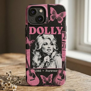 Könnte beinhalten: Eine schwarze und rosafarbene Smartphone-Hülle mit einer Grafik von Dolly Parton, die ein Mikrofon hält. Das Design enthält den Text DOLLY und 1946 - FOREVER, akzentuiert durch rosa Schmetterlingsillustrationen und zwei Akustikgitarren im unteren Bereich.