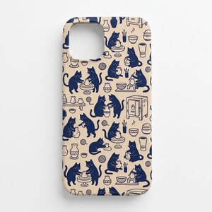 May include: A beige phone case featuring a repeating pattern of dark blue cats engaged in pottery activities. The design includes illustrations of cats using pottery wheels, shaping clay vessels, and standing near kilns and various ceramic items.