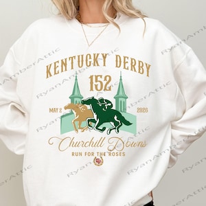 May include: White sweatshirt featuring a graphic for the Kentucky Derby. The design includes the text "KENTUCKY DERBY 152" with the date "MAY 2 2026" and "Churchill Downs RUN FOR THE ROSES". The graphic also features two horses racing.