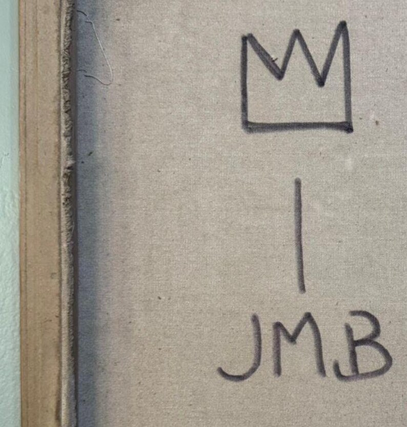 May include: A close-up of a canvas with a black crown drawing above a vertical line. Below the line are the black letters "JMB". The canvas has a beige color and is framed with a brown border.