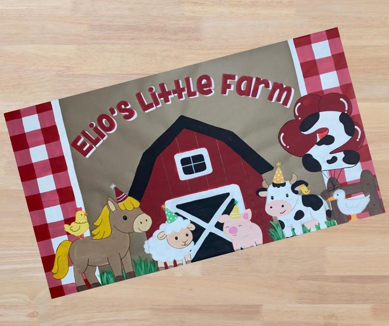 Op de afbeelding: Een rechthoekig bord met de tekst "Elio's Little Farm" boven een rode schuurillustratie. Tekenfilm dieren, waaronder een paard, een schaap, een varken, een koe en een eend, dragen feesthoeden. Rood-witte geblokte randen omlijsten het ontwerp.