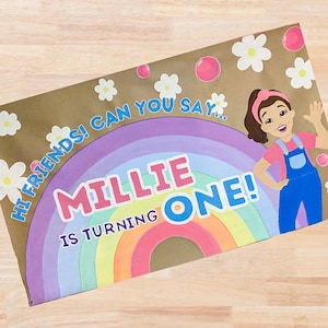 Op de afbeelding: Een bruine papieren uitnodiging met een regenboog, madeliefjes en de tekst "Millie is turning ONE!". Een cartoonmeisje in een blauwe overall zwaait. De tekst "Hi friends! Can you say..." is ook aanwezig.