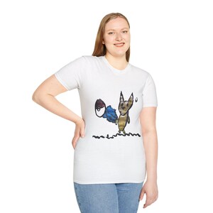 Pode incluir: Camiseta branca com um desenho de raposa de desenho animado. A raposa tem uma cauda azul e marrom e é desenhada em um estilo lúdico com contornos pretos. O desenho inclui linhas onduladas pretas na parte inferior. A camiseta é feita de material macio.