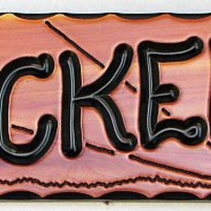 May include: A wooden sign with a sunset scene and a palm tree. The sign reads "the CROCKER'S" in black lettering.