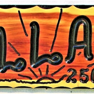 May include: A wooden sign with a yellow and orange background and black lettering. The sign reads "the WOOLATT'S" and "2505 Birch Ave."