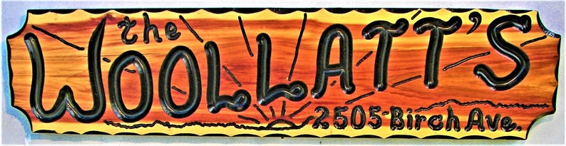 May include: A wooden sign with a yellow and orange background and black lettering. The sign reads "the WOOLATT'S" and "2505 Birch Ave."