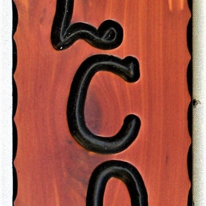 May include: Wooden sign with the word "WELCOME" in black outlined letters. The sign has a red cardinal perched on a branch and a deer silhouette at the bottom.